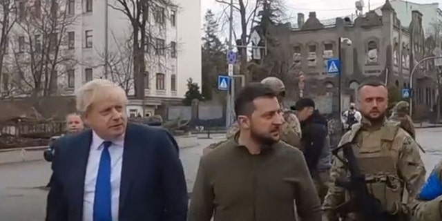 Auf der linken Seite gehen der Premierminister des Vereinigten Königreichs und der ukrainische Präsident Wolodymyr Selenskyj durch die Straßen von Kiew. 
