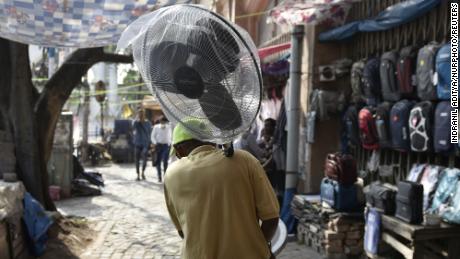 Ein Mann hält während einer Hitzewelle in Kalkutta, Indien, einen Ventilator.