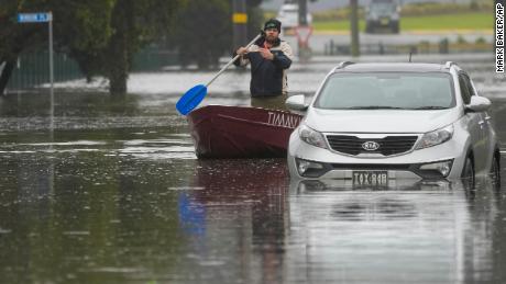 Ein Mann rudert mit seinem Boot auf einer überfluteten Straße in Windsor am Stadtrand von Sydney, Australien, 5. Juli 2022.