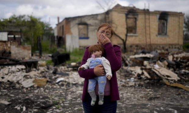 Nella Zelenska hält im Mai eine Puppe ihrer Enkelin vor ihrem zerstörten Haus in Potashnya, außerhalb von Kiew, Ukraine.