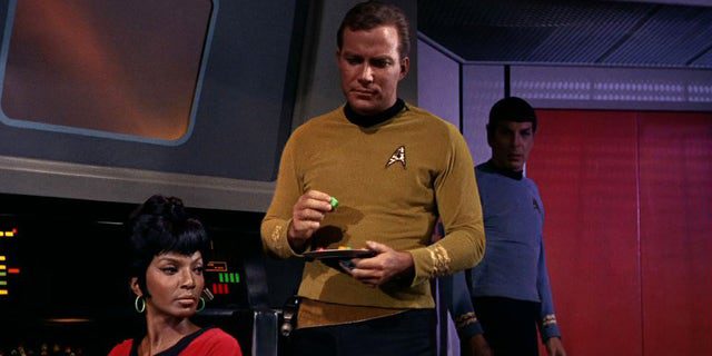 Nichelle Nichols (als Lieutenant Nyota Uhura) und William Shatner (als Captain James T. Kirk) werden in einer Szene aus gezeigt "Mann Falle" Die erste Folge von "Star Trek" die am 08.09.1966 ausgestrahlt wurde.