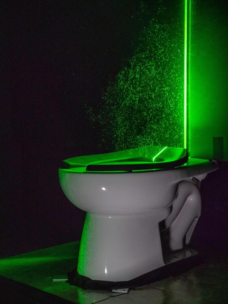 Der leistungsstarke grüne Laser hilft, die Aerosolwolken von der Toilette sichtbar zu machen 